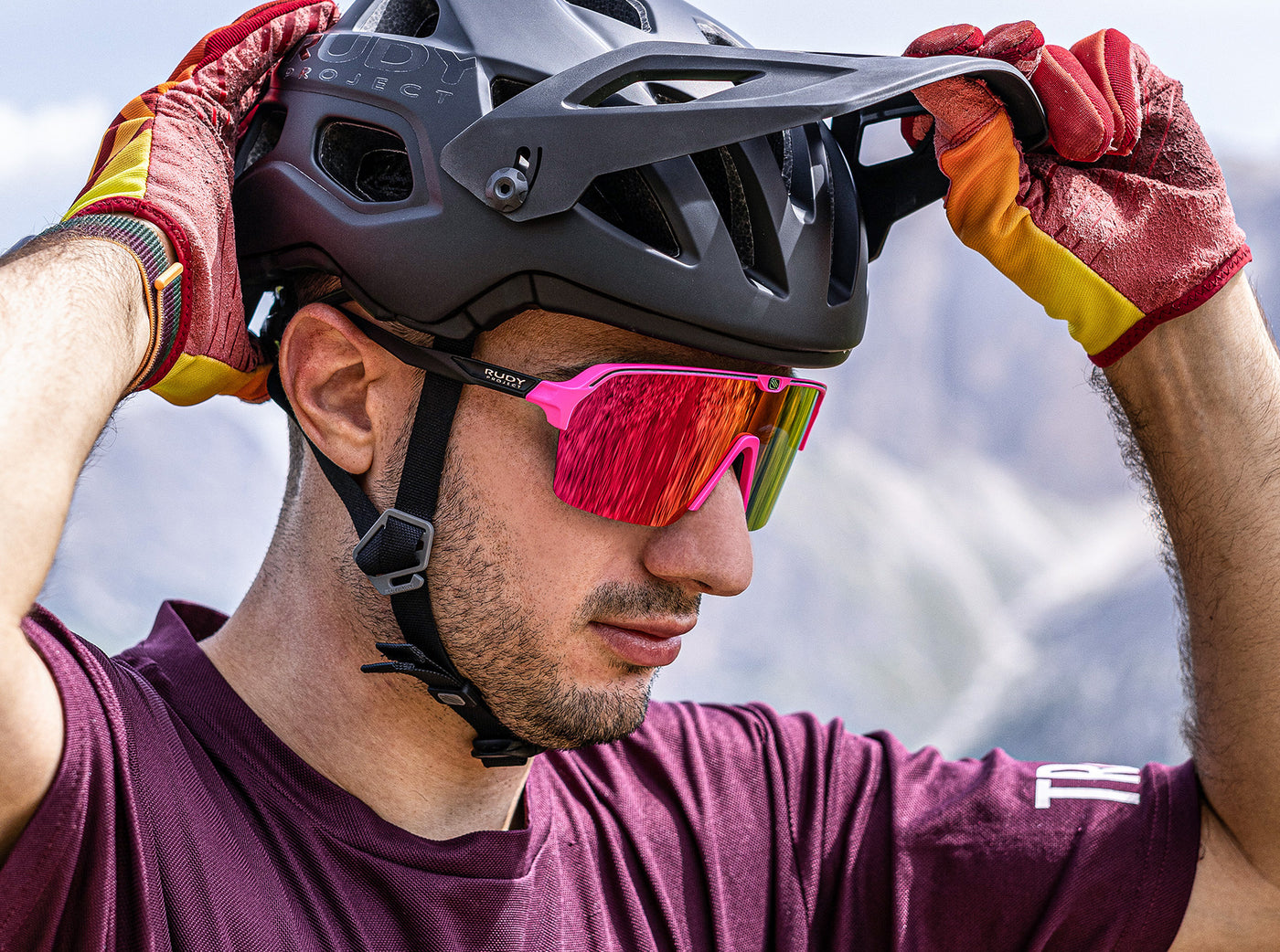 Mountain biker wearing Rudy Project Protera+ helmet with adjustable visor and goggle clip, and also Spinshield Air wide shield sunglasses