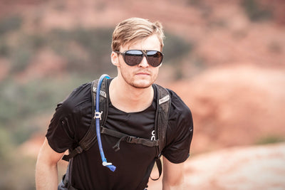 Rudy Project Stardash glacier sunglasses worn by man hiking and wearing a hydration backpack
